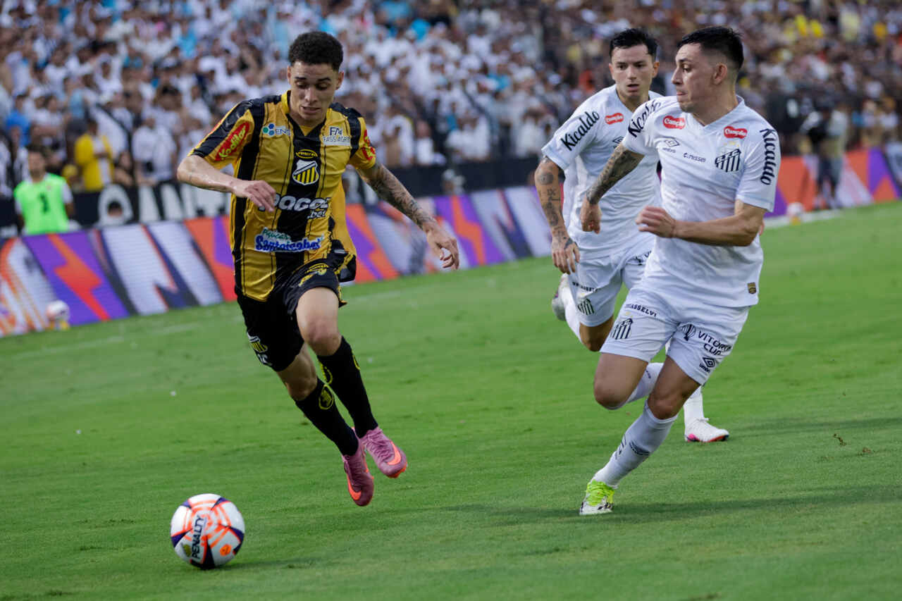 O santista Escobar atento ao avanço de Tavinho. Foto: Divulgação / Grêmio Novorizontino