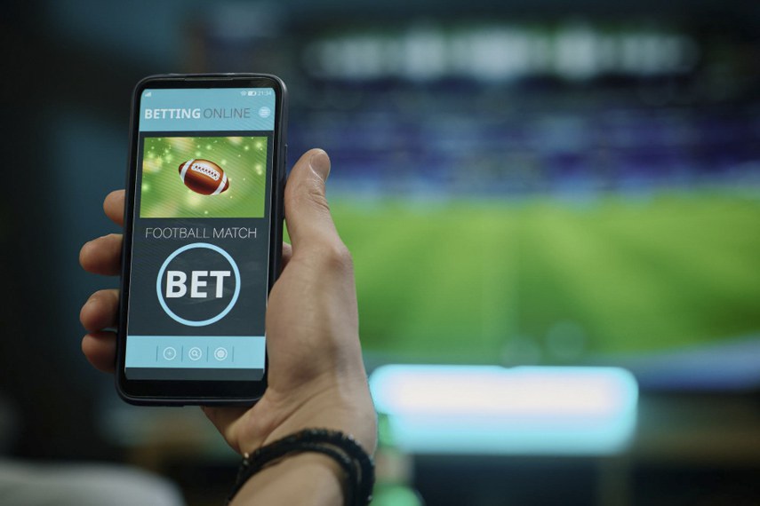Celular e cédulas de real ilustram a devolução de R$ 159 milhões aos apostadores após a proibição das bets no Brasil.