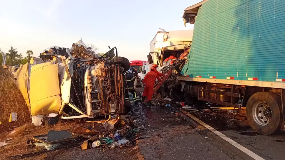 Caminhão tombado e outro com a cabine destruída após colisão na BR-343, com equipes de resgate trabalhando entre os veículos.