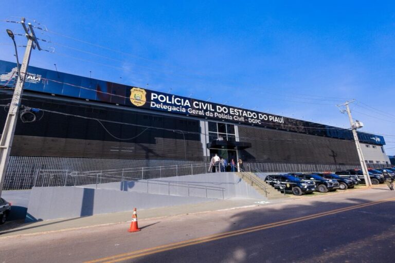Fachada da Delegacia-Geral da Polícia Civil do Piauí, com letreiro da instituição e viaturas estacionadas à frente.