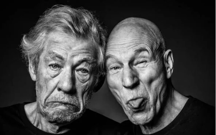 Retrato em preto e branco de Ian McKellen, à esquerda, com expressão séria, e Patrick Stewart, à direita, fazendo uma careta com a língua para fora.