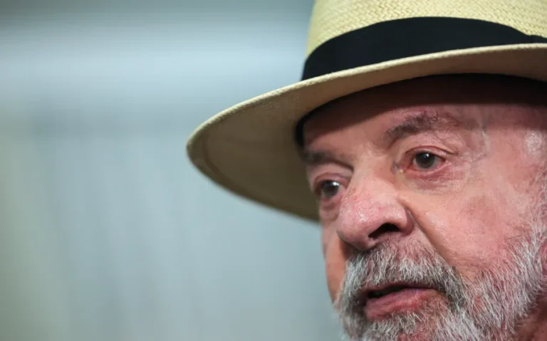 Presidente Luiz Inácio Lula da Silva usando chapéu claro com faixa preta durante cerimônia oficial em Brasília.