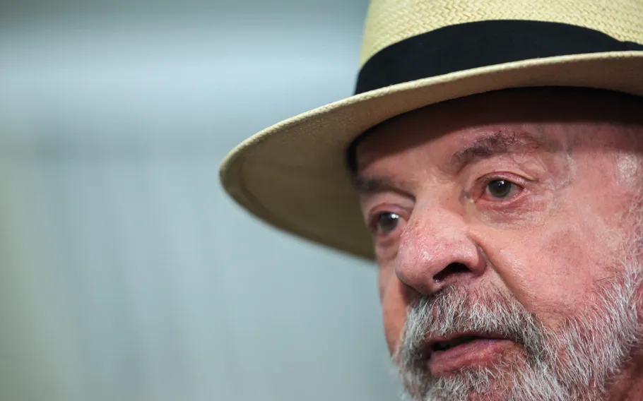 Presidente Luiz Inácio Lula da Silva usando chapéu claro com faixa preta durante cerimônia oficial em Brasília.