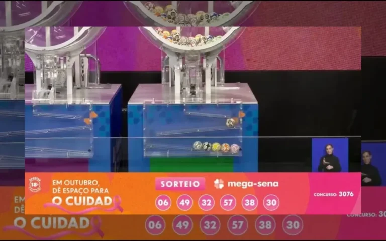 Transmissão do sorteio da Mega-Sena 3076 mostra as dezenas 06, 49, 32, 57, 38 e 30, com equipamentos de sorteio ao fundo e intérprete de Libras.