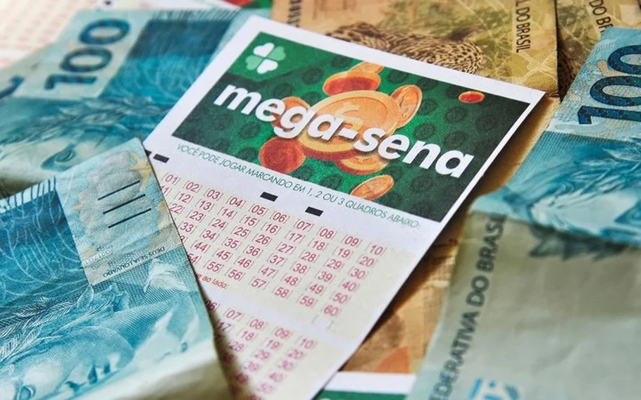Volante de apostas da Mega-Sena sobre cédulas de dinheiro brasileiro, incluindo notas azuis de R$ 100.
