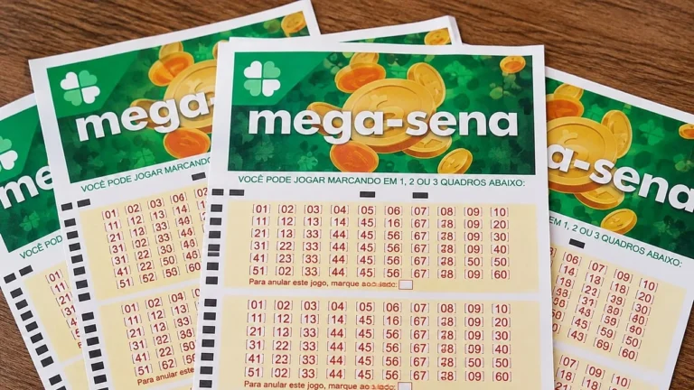 Volantes da Mega-Sena sobre uma mesa de madeira, com o logotipo verde da loteria e quadros de números para apostas.