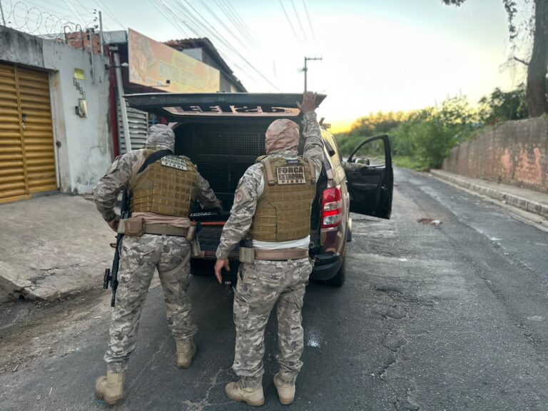 Agentes da Força Estadual Integrada de Segurança Pública do Piauí durante ação policial junto a uma viatura.