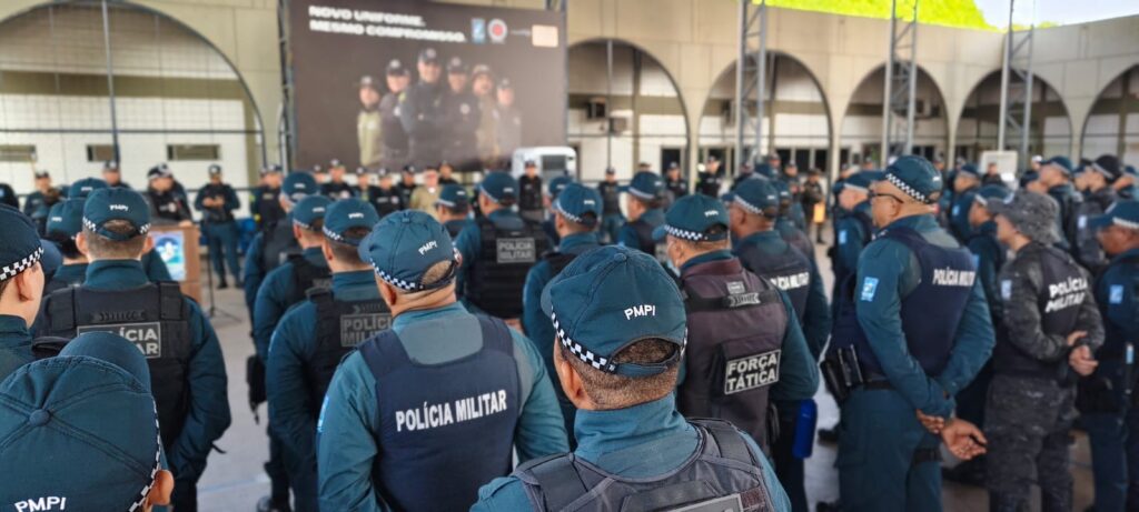 Policiais militares do Piauí, usando fardas azuis e coletes táticos, reunidos em formação diante de um prédio com grandes arcos.