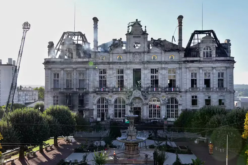 Fachada da prefeitura de Limoges após incêndio, com estrutura do telhado exposta e parcialmente destruída.