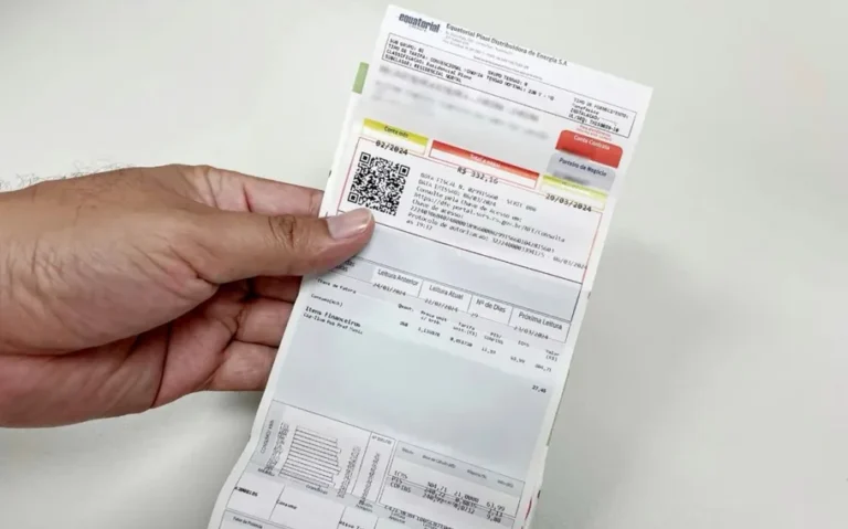 Mão segura uma fatura impressa da Equatorial Piauí, com QR Code e informações de cobrança, sobre uma superfície clara.