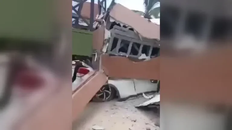 Estruturas de construção danificadas, com paredes destruídas e escombros espalhados pelo chão.