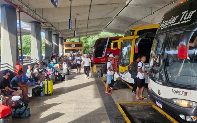 Plataforma da Rodoviária de Teresina com ônibus estacionados, passageiros aguardando embarque e bagagens ao lado dos bancos.