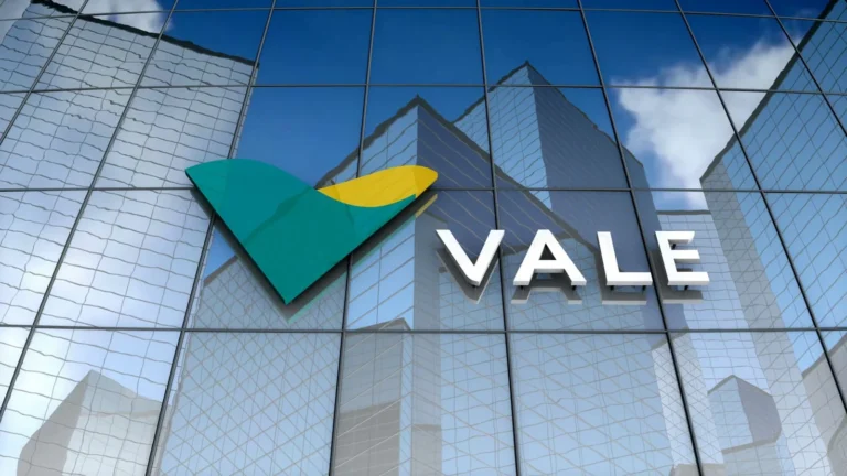 Logotipo verde e amarelo da Vale e nome da mineradora em letras brancas sobre a fachada espelhada de um edifício.
